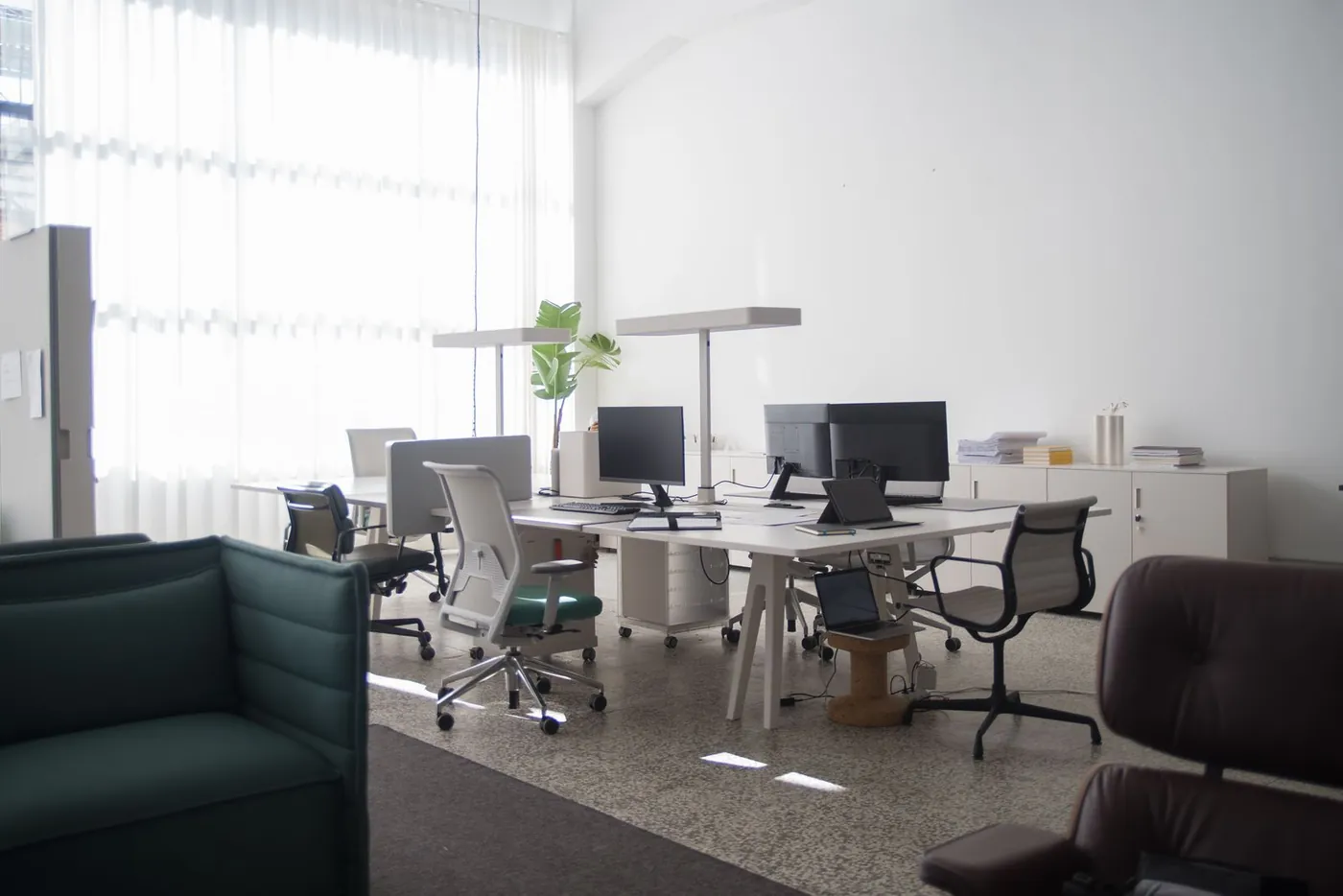 Office desks and chairs in a naturally lit workspace.